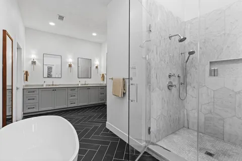 a bathroom with a double vanity sink toilet and shower