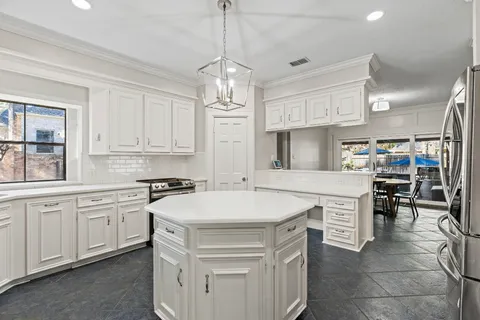 a kitchen that has a lot of cabinets in it and white cabinets
