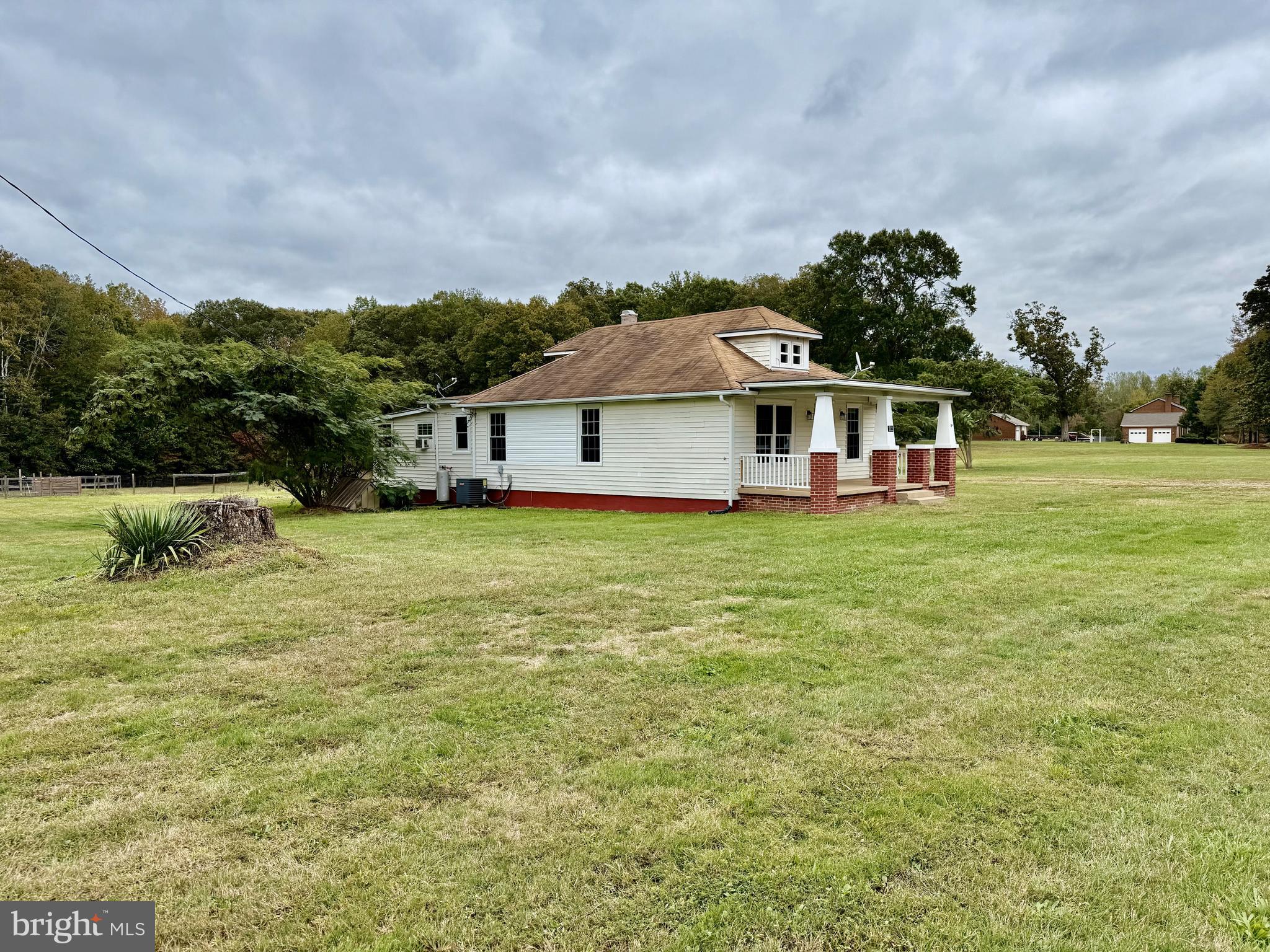 a view of a house with a big yard and large trees