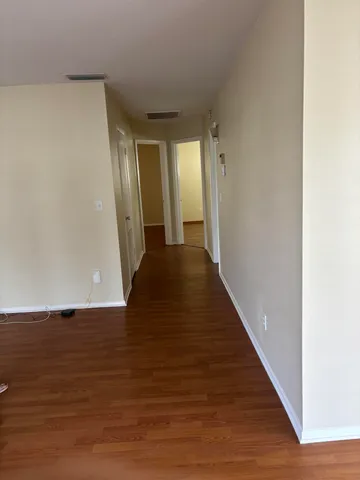 a view of a hallway with wooden floor