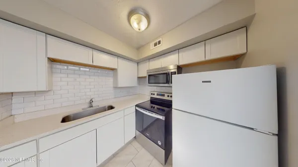 a kitchen with stainless steel appliances a refrigerator sink and cabinets