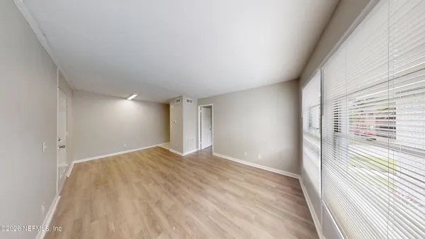 a view of empty room with wooden floor and fan