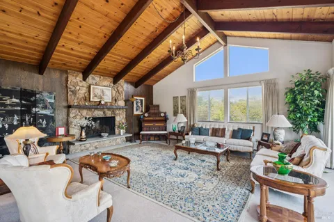 a living room with fireplace furniture and a large window
