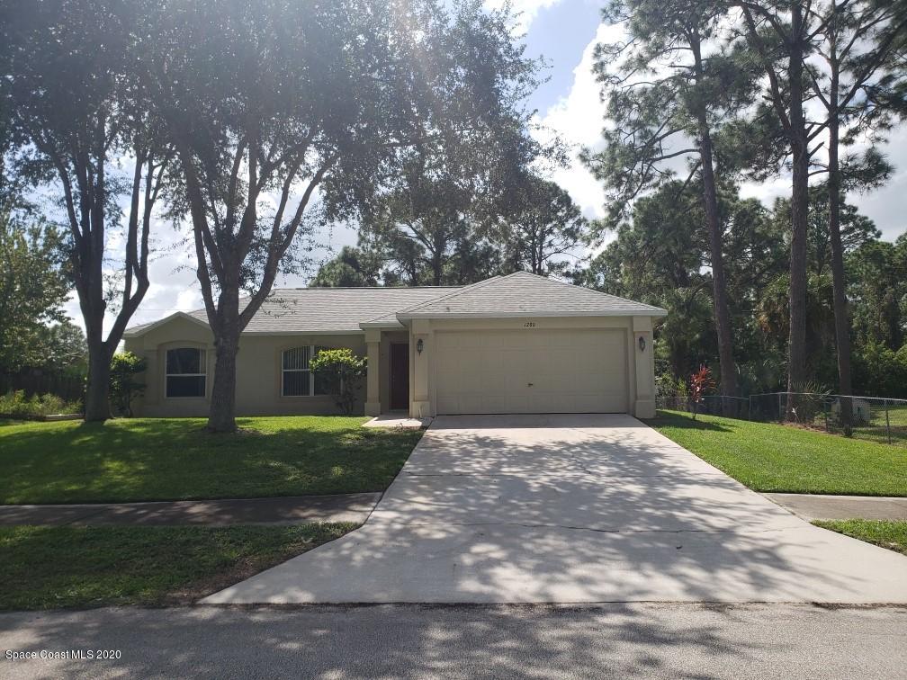 1280 Seabold Road Southwest Palm Bay, FL 32908 - Photo 1 of 28 a front view of a house with a yard and garage