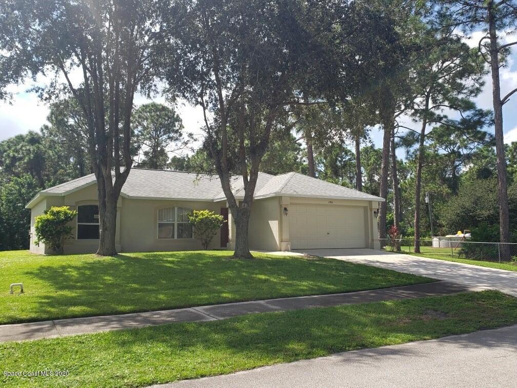 1280 Seabold Road Southwest Palm Bay, FL 32908 - Photo 2 of 28 a front view of a house with a yard and garage