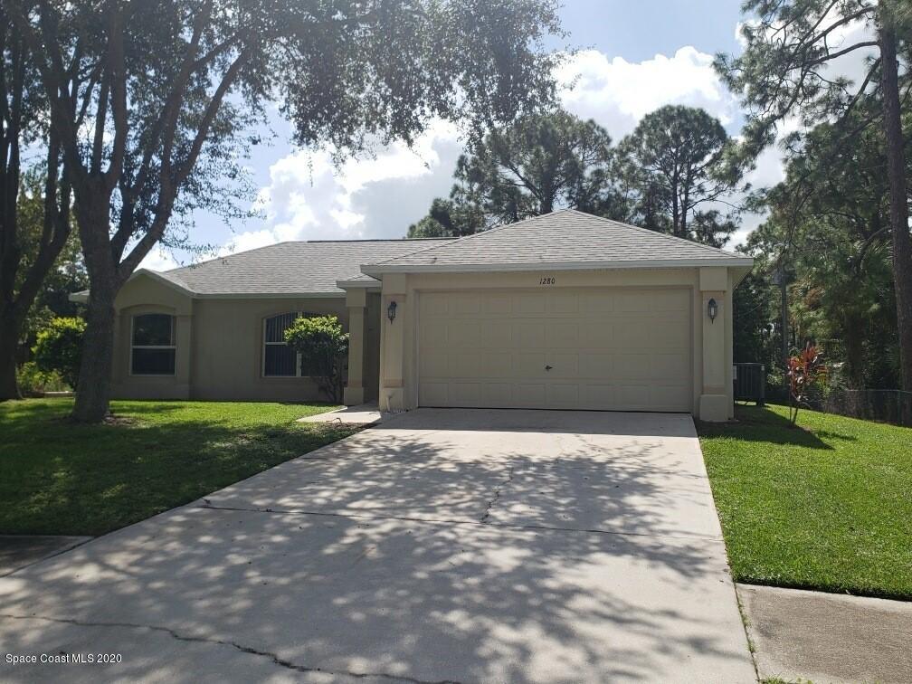 1280 Seabold Road Southwest Palm Bay, FL 32908 - Photo 3 of 28 a front view of a house with a garden and trees