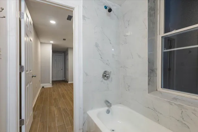 a bathroom with a bathtub and shower