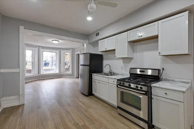 a kitchen with granite countertop a stove a sink and a refrigerator