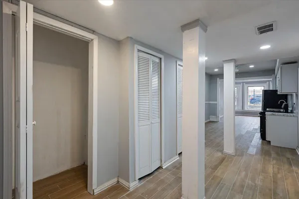 a view of a hallway with wooden floor and a living room