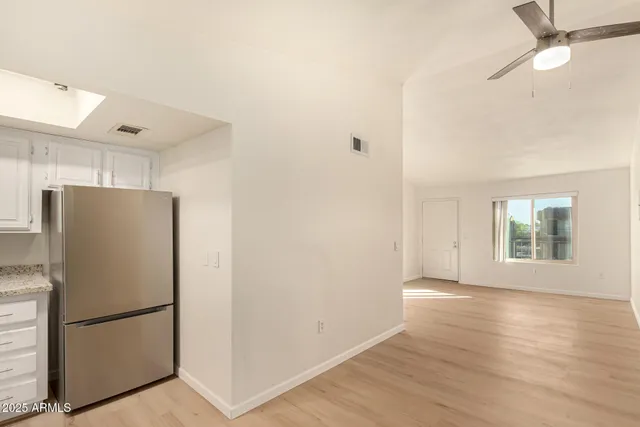 a view of a kitchen with refrigerator and wooden floor