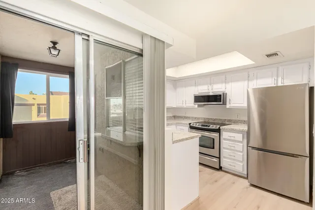 a kitchen with stainless steel appliances granite countertop a refrigerator and a stove top oven