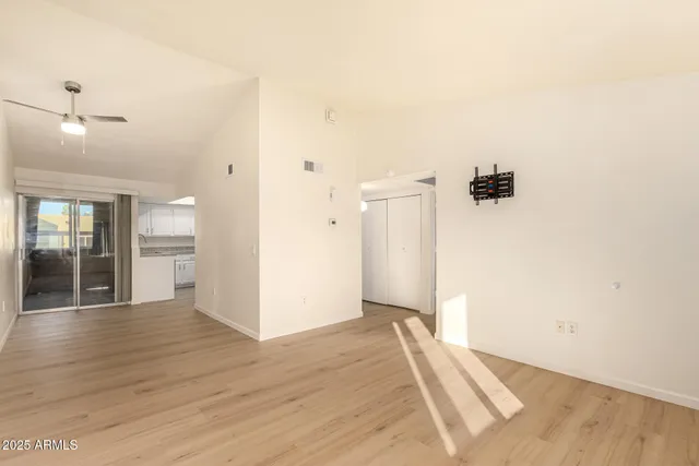 a view of a hallway with wooden floor and a bathroom