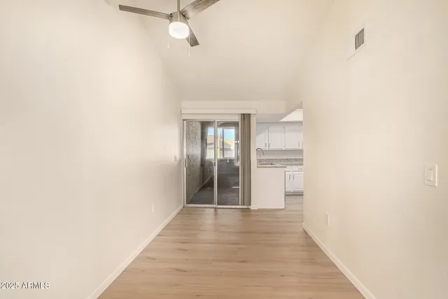 a view of a hallway with wooden floor and a bathroom