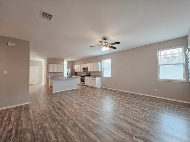 a view of kitchen with microwave and wooden floor