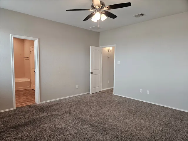 an empty room with closet and a chandelier fan