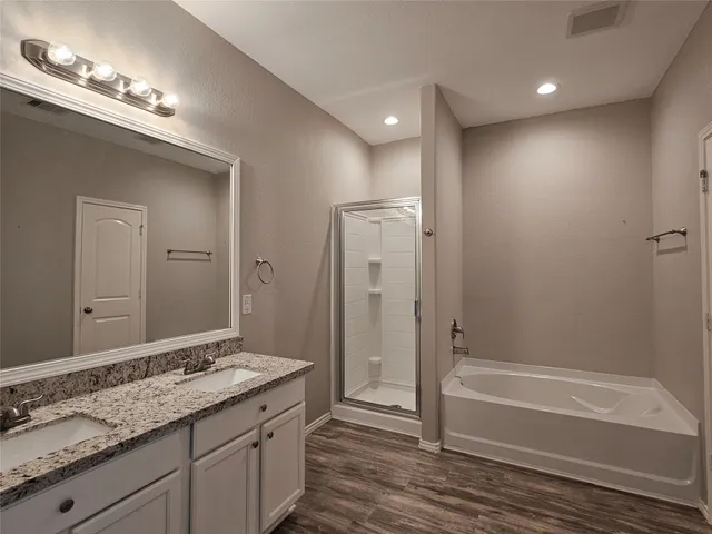 a bathroom with a granite countertop sink a toilet and shower