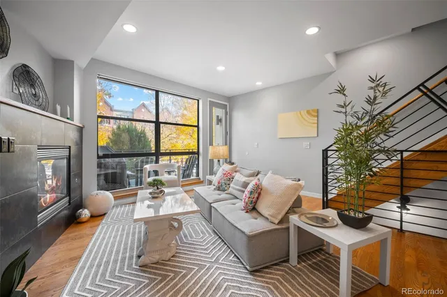 a living room with furniture large window and flat screen tv