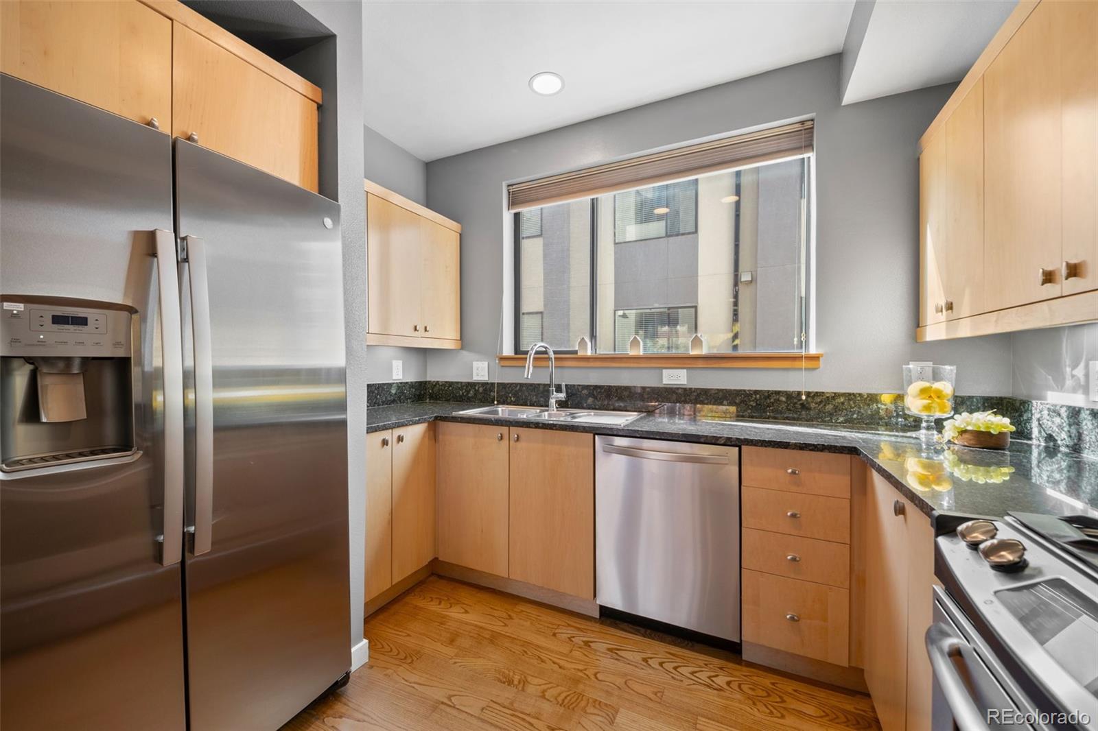 516 24th Street Denver, CO 80205 - Photo 12 of 42 a kitchen with stainless steel appliances granite countertop a refrigerator a sink and white cabinets