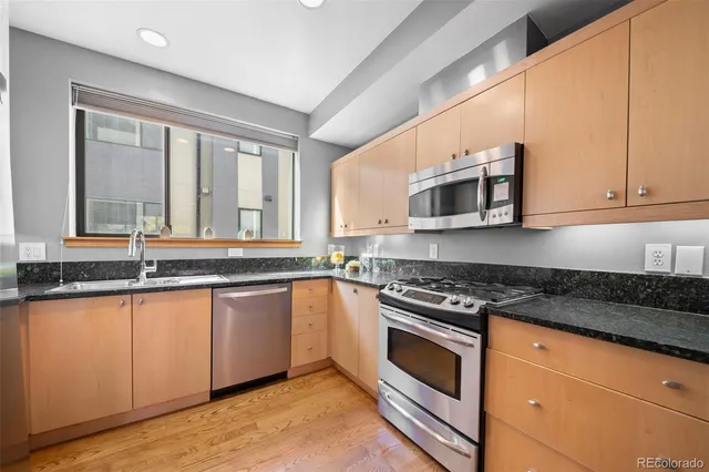 a kitchen with granite countertop a stove sink and microwave