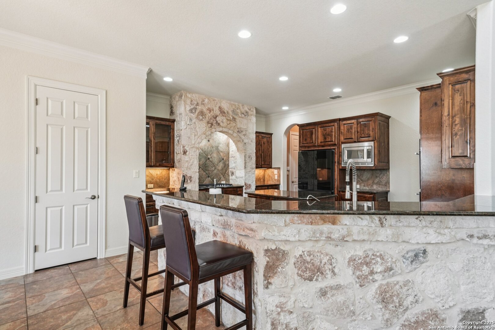 718 Ruidosa Downs Helotes, TX 78023 - Photo 11 of 50 a view of a dining room with kitchen island granite countertop a table and chairs in it
