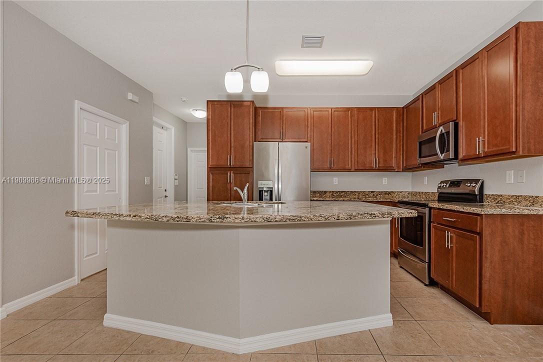 6321 South Station Square, Unit 6321 Davie, FL 33314 - Photo 4 of 7 a kitchen with stainless steel appliances granite countertop wooden cabinets a stove a sink and a refrigerator