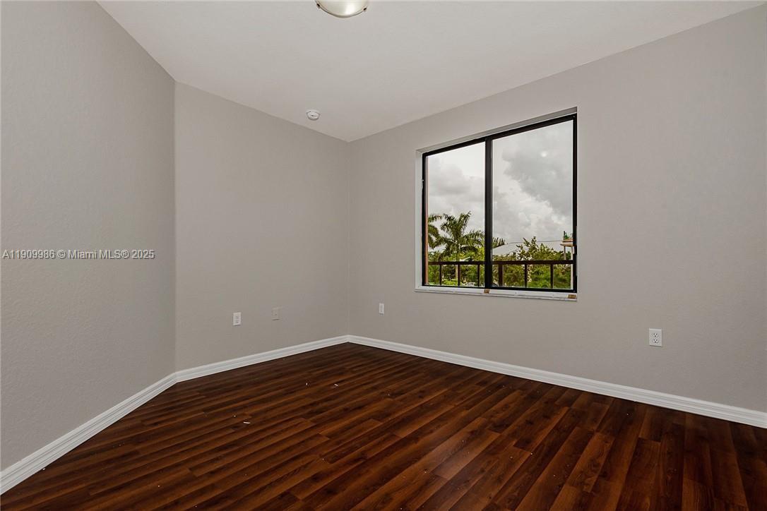 6321 South Station Square, Unit 6321 Davie, FL 33314 - Photo 6 of 7 a view of an empty room with wooden floor and a window