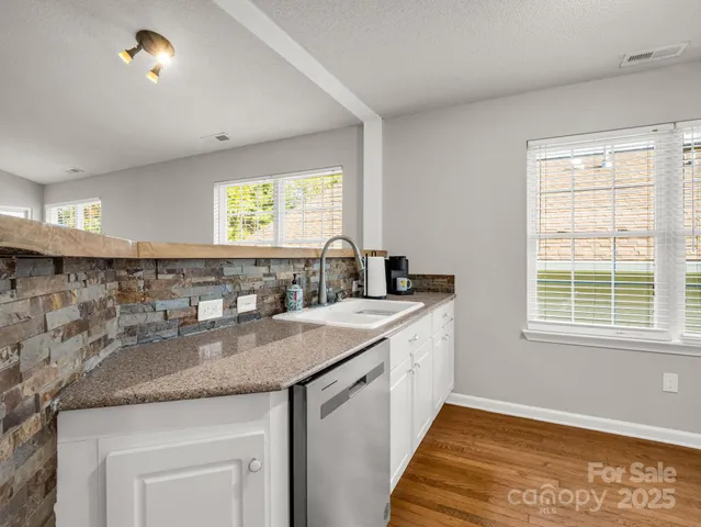 a kitchen with stainless steel appliances granite countertop a refrigerator stove and sink