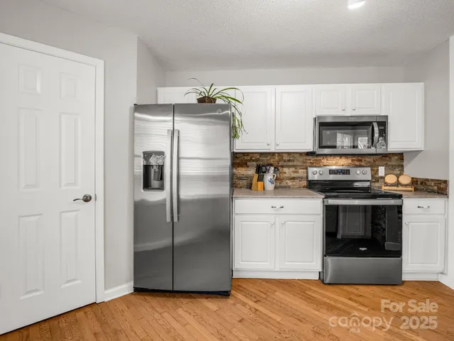 a view of a kitchen with a dining table chairs and windows