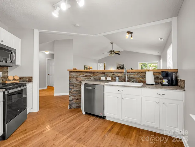 a view of a kitchen cabinets a sink and wooden floor