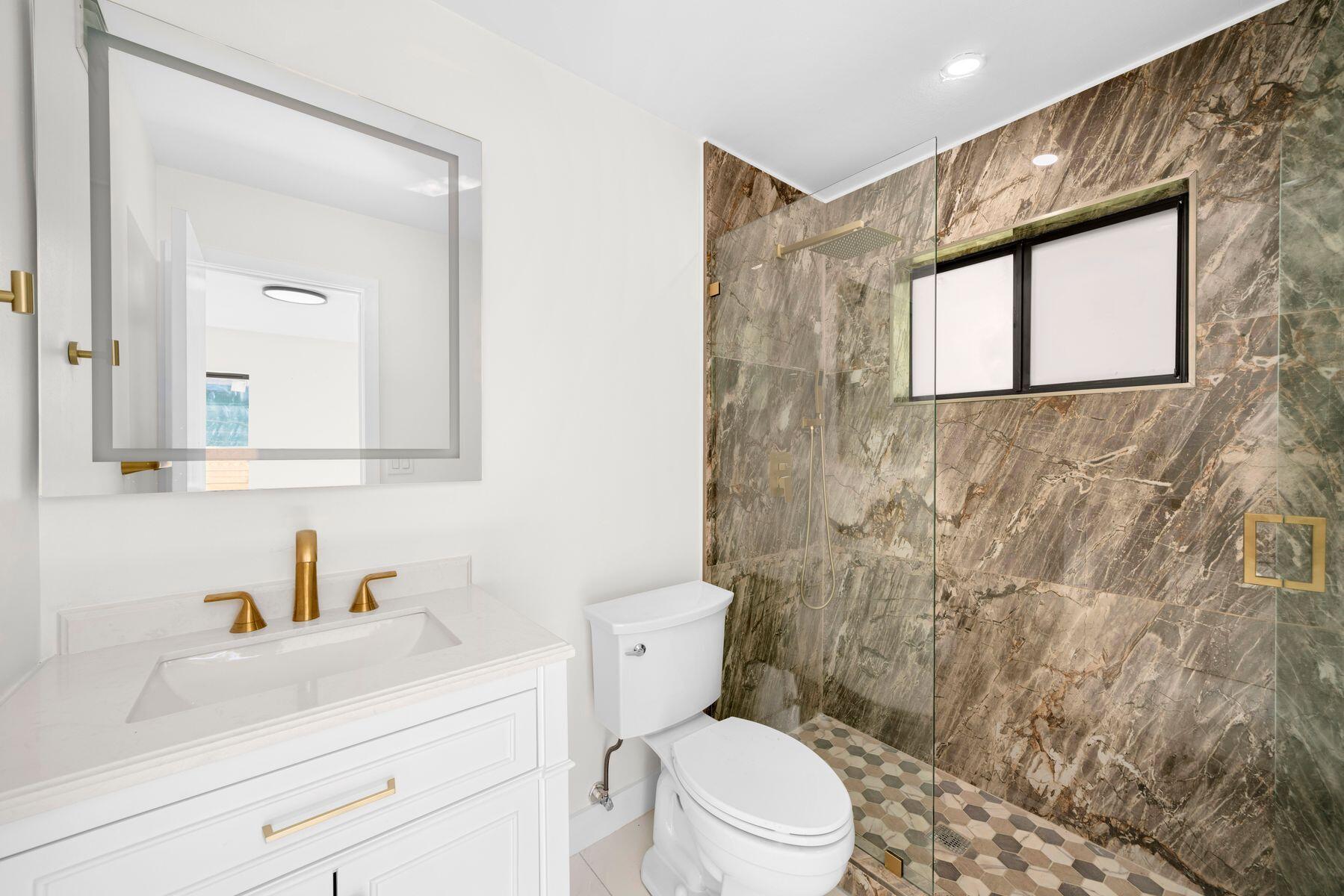 1367 Northwest 41st Street Miami, FL 33142 - Photo 14 of 20 a bathroom with a toilet sink vanity and mirror