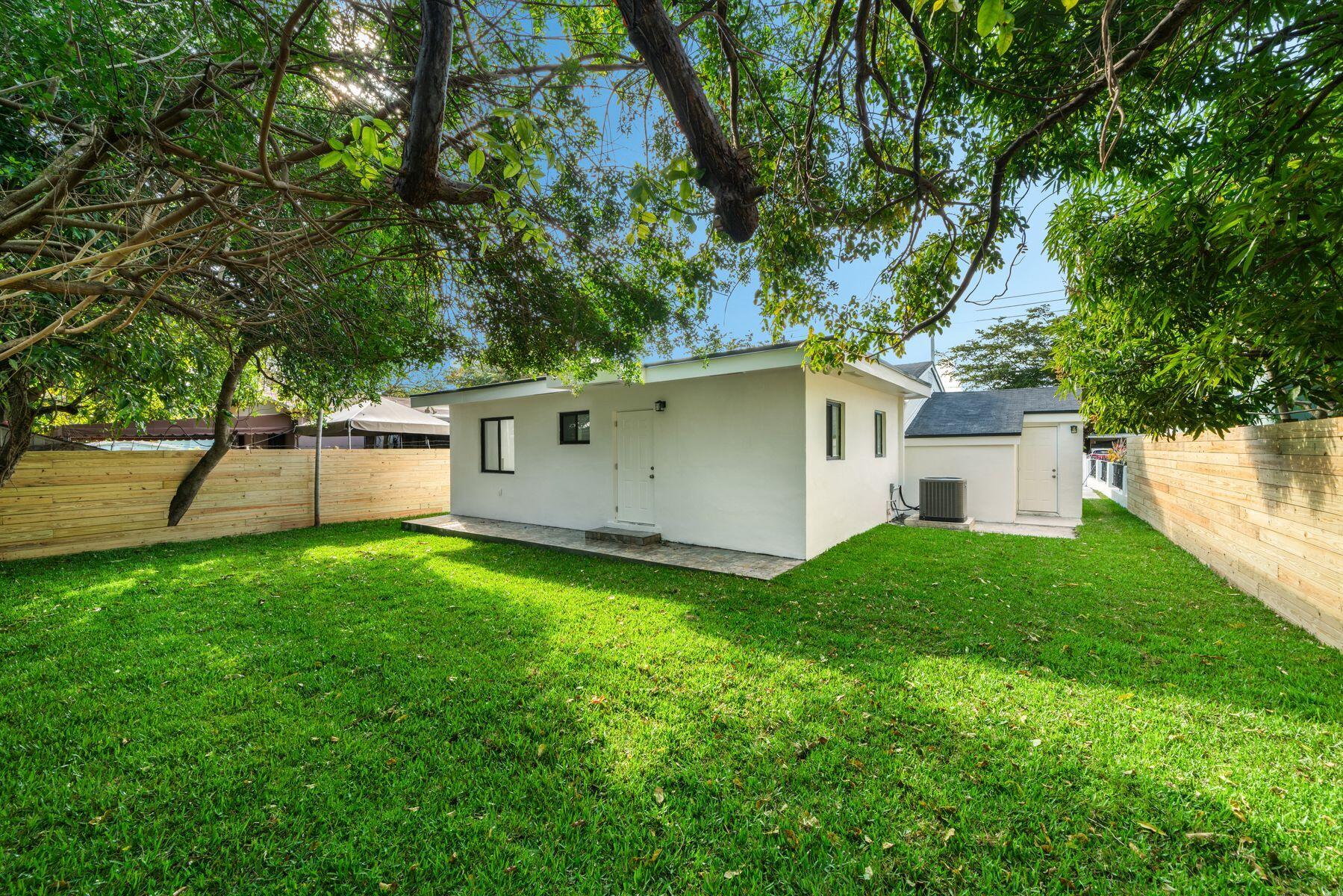 1367 Northwest 41st Street Miami, FL 33142 - Photo 16 of 20 a view of a backyard with plants and a large tree