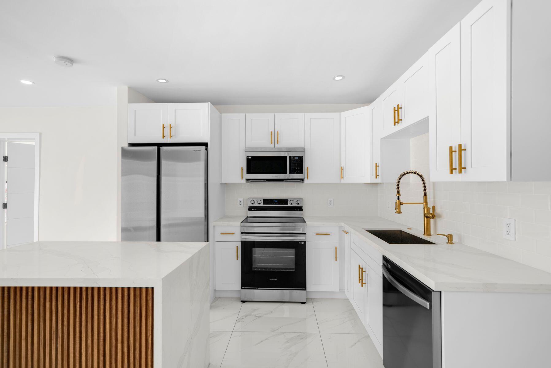 1367 Northwest 41st Street Miami, FL 33142 - Photo 5 of 20 a kitchen with granite countertop white cabinets and stainless steel appliances
