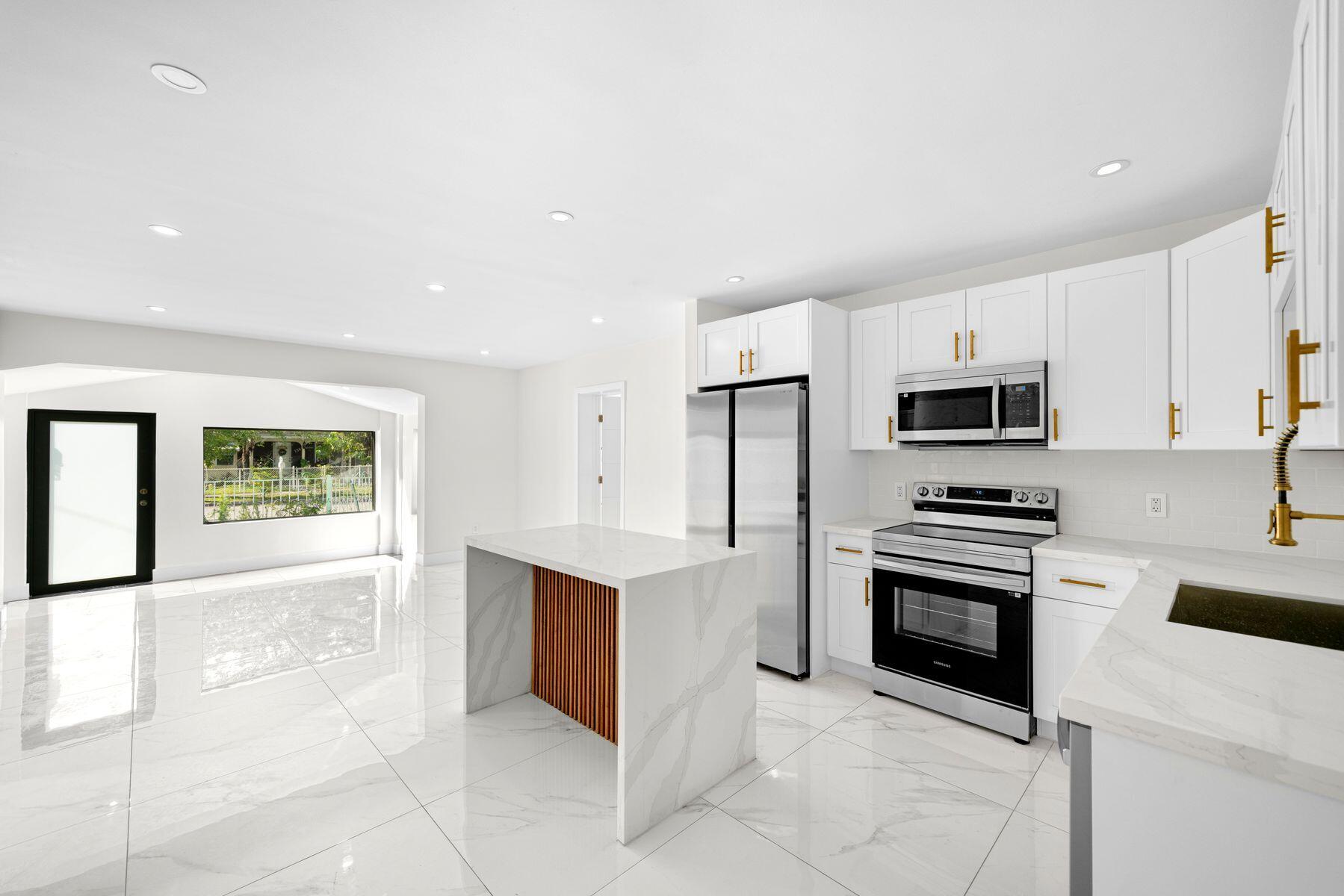 1367 Northwest 41st Street Miami, FL 33142 - Photo 6 of 20 a kitchen with stainless steel appliances a stove sink and microwave
