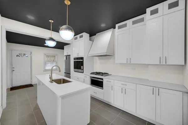 a kitchen with stainless steel appliances granite countertop a sink a stove and a refrigerator