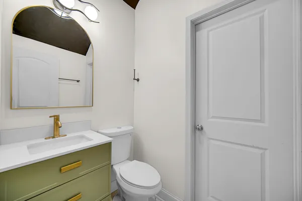 a bathroom with a toilet sink and mirror