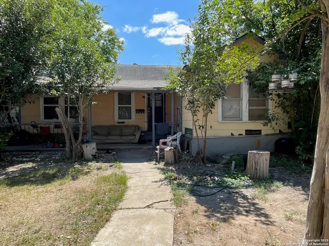 a view of a house with backyard and sitting area