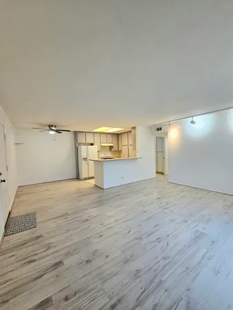 a view of empty room with wooden floor