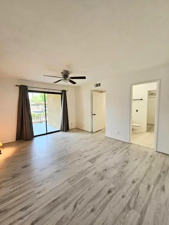 a view of empty room with wooden floor and window