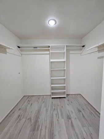 a view of walk in closet with empty racks