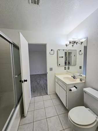 a spacious bathroom with a double vanity sink toilet and shower