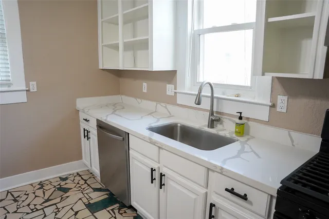 a kitchen with a sink cabinets and window