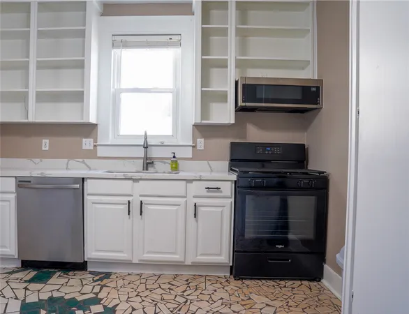 a kitchen with stainless steel appliances granite countertop a stove and a microwave