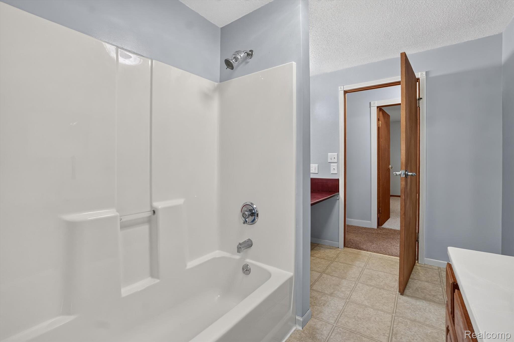 10977 Maple Road Birch Run, MI 48415 - Photo 25 of 49 Tub and shower combination with white surround, chrome fixtures, and tiled flooring