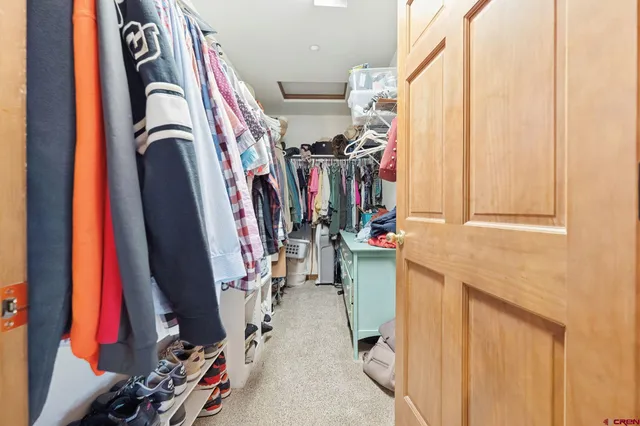 a view of walk in closet with clothes