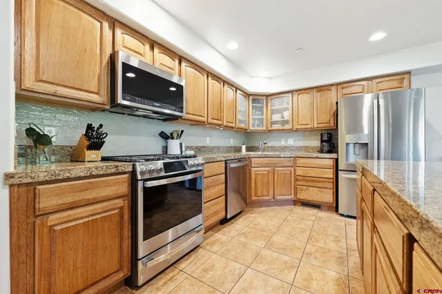 a kitchen with stainless steel appliances granite countertop a stove top oven a sink dishwasher and a microwave oven with cabinets