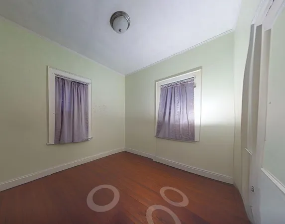 a view of an empty room with window and closet