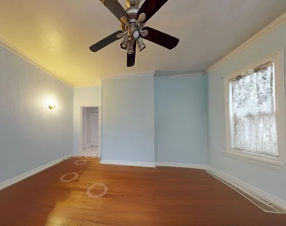 an empty room with windows and fan