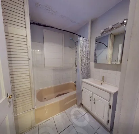 a bathroom with a tub sink and mirror