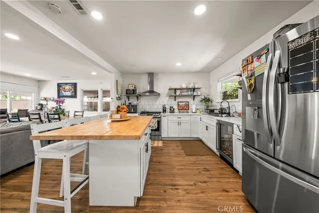 a large kitchen with stainless steel appliances kitchen island granite countertop a refrigerator and a stove top oven