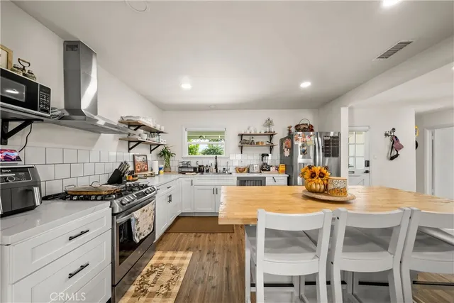 a kitchen with stainless steel appliances a stove a sink dishwasher and a refrigerator